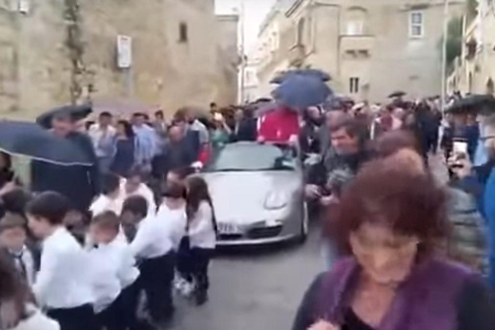 Padre em Porsche puxado por 50 crianças durante procissão [vídeo]