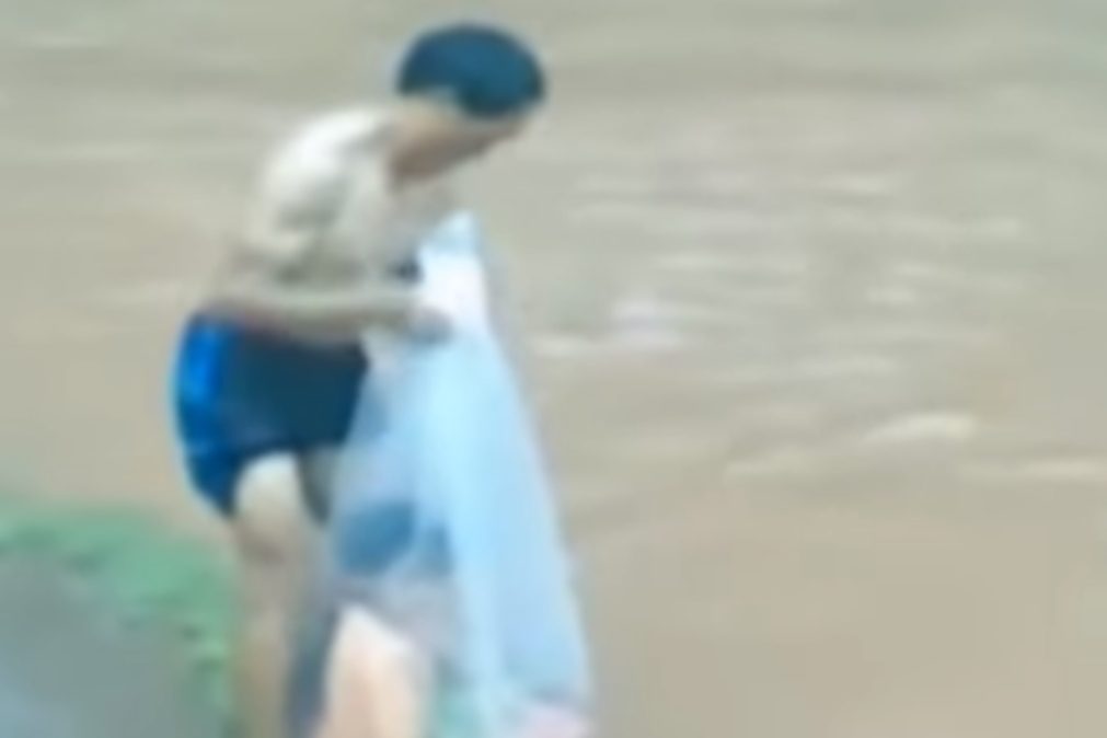 Crianças atravessam rio em sacos de plástico para irem para a escola no Vietname