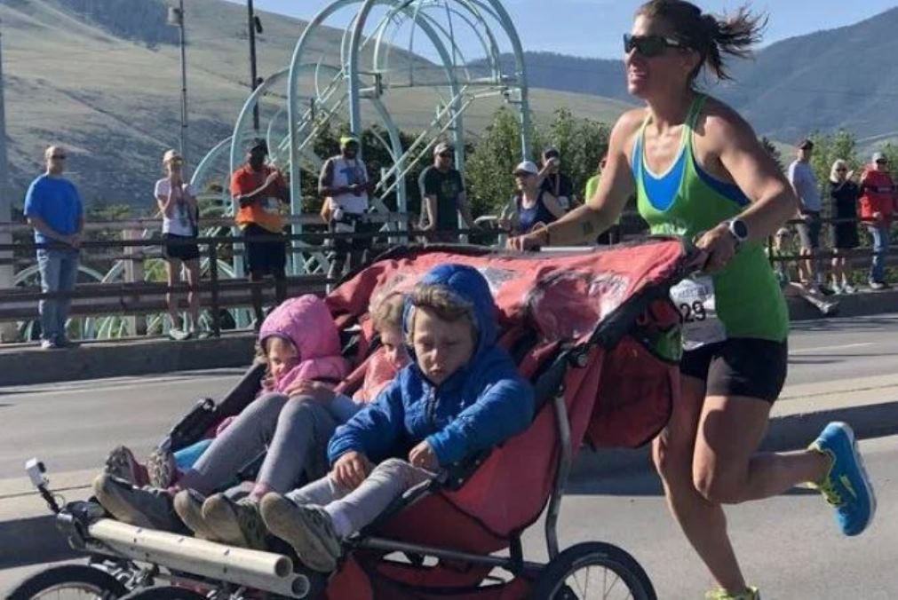 Mãe termina maratona enquanto empurra carrinho com os três filhos